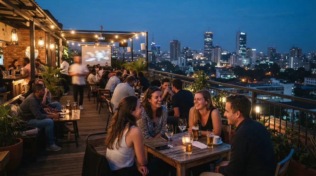 la terraza en la azotea de Unseen Nairobi sobre Wood Avenue al atardecer, con vistas al horizonte, mesas, luces cálidas y cinéfilos quedándose después de la proyección